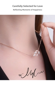 Rose gold leaf pendant necklace with white zircons worn on a model's neck