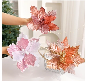 Detail of glittered artificial poinsettia flowers in pink and gold for Christmas decor