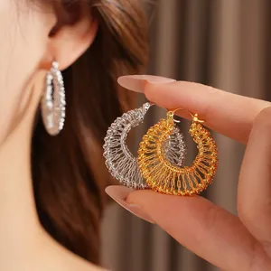 Strukturierte goldene und silberne gewebte Creolen im minimalistischen Luxusdesign