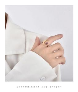 Detail of gold crescent moon ring with purple natural stone on model in white suit