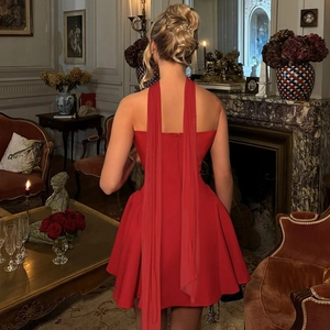 Detail of red backless mini dress with elegant long ribbons and rear zipper closure