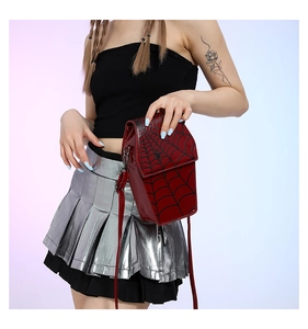 Model wearing a red spider web pattern coffin shaped PU leather crossbody bag with chain