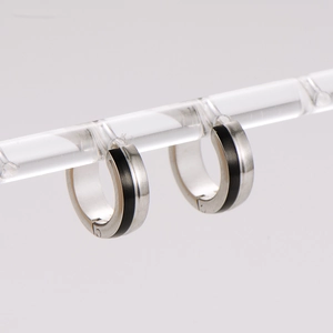 Detail of minimalist stainless steel huggie earrings with black stripe inlay and brushed finish