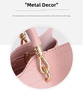 Detail of pink faux crocodile leather texture and golden metal hardware on handbag