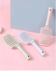 Makro-Detail der ergonomischen Haarbürste mit Macaron-Farben und Kopfhautmassageborsten