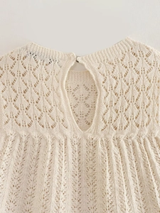Dettaglio maglia traforata a rombi con chiusura a goccia con bottone sul retro