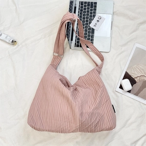 Detail of pink pleated hobo bag with adjustable metal buckle strap and soft fabric texture