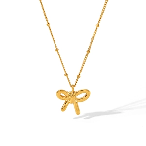 Detail showing an 18K gold-plated bow pendant with delicate beaded chain texture