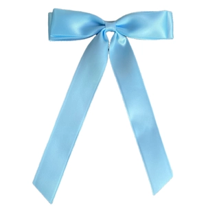 Macro detail of a light blue satin double-layered bow hair clip with elegant long ribbons