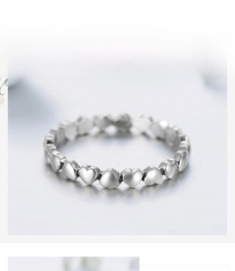 Close-up of S925 sterling silver ring with small 3D heart shapes in a continuous band