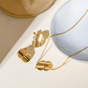Flat lay of 18k gold plated stainless steel jewelry set with abstract geometric shapes