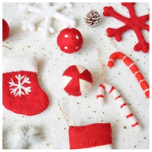 Detail of handmade wool felt Christmas ornaments with stockings and snowflakes