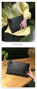 Detailopname van een zwarte clutch van lychee-leer met metalen klinknagels en polsband