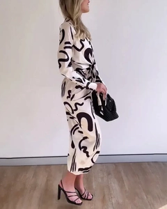 Details des eleganten elfenbeinfarbenen Langarm-Midikleids mit schwarzem Abstraktmuster