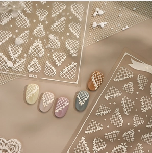 Macro detail of white embossed lace mesh nail stickers KX472 on colorful fake nails