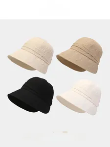 Detail view of foldable sun bucket hats showing four colors and pleated fabric texture