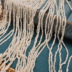 Macro shot of tiny 2.5mm natural freshwater pearls on elegant cyan velvet display