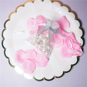 Detailed view of white pearls inside a sheer mesh pouch with a silver bow on a tray