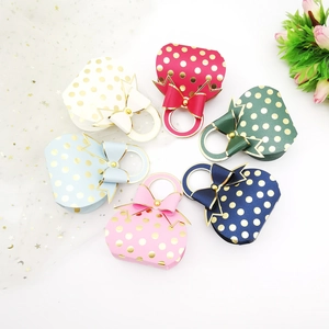 Top view of creative mini paper gift boxes with gold polka dots and bow decorations