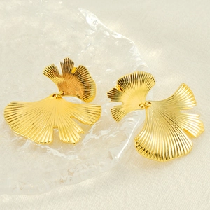 Macro detail of golden ginkgo leaf earrings with delicate radiating vein textures