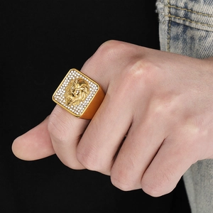 Detail of a gold square signet ring for men featuring a lion head and sparkling crystals