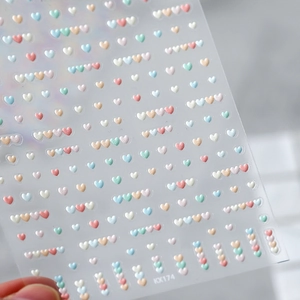 Macro view of 3D embossed heart nail stickers in pastel macaron colors model KX174