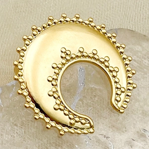 Macro shot of gold crescent moon ring featuring detailed beaded edges and ethnic style