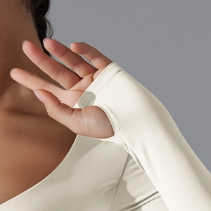 Dettaglio del top yoga beige con polsini a asola e tessuto opaco ad alta elasticità