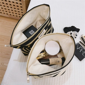 Inside view of striped canvas makeup bag with soft lining and smooth metal zipper