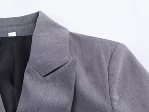 Gros plan du col et de l'épaule de la veste de costume grise à double boutonnage