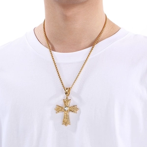 Vue détaillée d'un pendentif croix gothique punk doré avec cristal sur un modèle