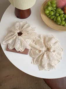 Close-up of beige lace embroidery scrunchie set with vintage floral scalloped edges