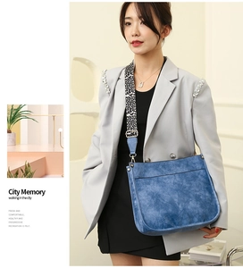 Close-up of blue textured tote bag with leopard print shoulder strap on a model