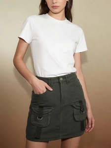 Detail of high-waisted dark green denim cargo skirt with large utility pockets and D-rings