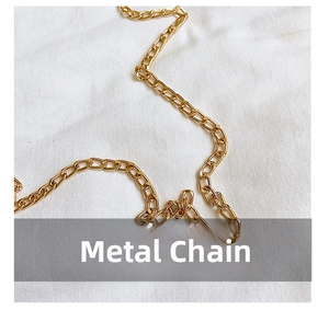 Close-up of high-polish golden metal chain strap on a textured white fabric background