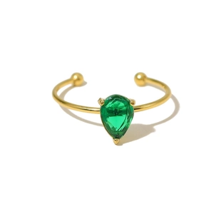 Detailed view of an adjustable gold-plated ring with a pear-cut emerald green gemstone
