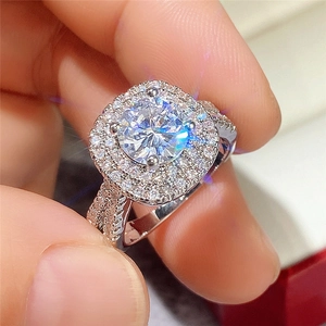 Classic double halo engagement ring featuring a round cut center stone and paved band