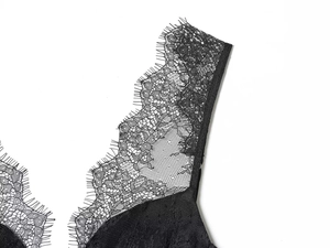 Detailopname van de verfijnde zwarte wimperkant en de delicate mesh textuur van stof
