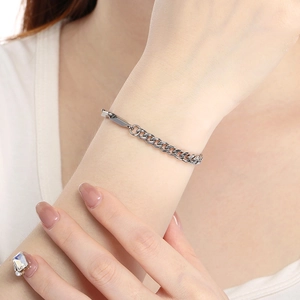 Close-up of silver Cuban link chain bracelet on wrist showing metallic luster and texture
