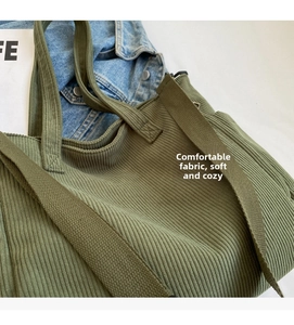 Detail of olive green corduroy tote bag showing textured fabric and wide shoulder straps