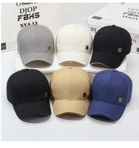 Detail view of cotton baseball caps in five colors with retro metal badges and curved brims