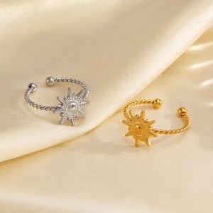 18K gold and silver sun-shaped open rings with twisted band on beige silk background