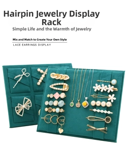 Detail of dark green suede display stand with slots for hair clips and pearl necklaces