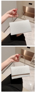 Detail van een sprankelende zilveren avondclutch met elegante ronde metalen handgreep