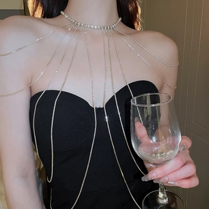 Exquisite rhinestone long shoulder and body chain worn over a stylish black top