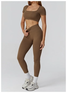 Detail of high-waist seamless yoga pants and crop top set in deep coffee brown ribbed fabric