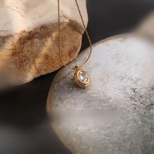 Close-up of a vintage oval zircon pendant on a gold plated titanium steel chain necklace