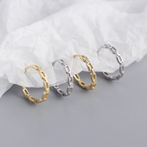 Detailed view of gold and silver chain rings with small diamonds on white paper