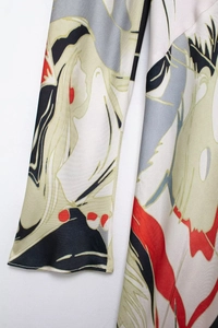 Detailed view of satin fabric with abstract geometric patterns and silky texture on cuff