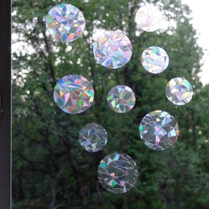 Detailed view of circular rainbow prism window films with holographic geometric patterns